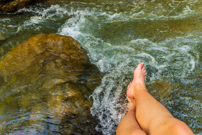 Low woman of person legs by flowing water