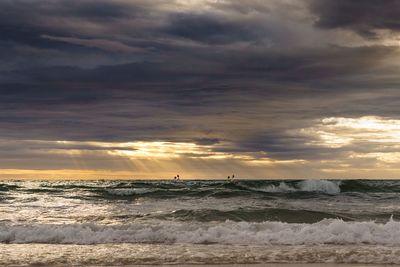 View of beach against cloudy sky during sunset