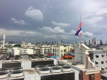 Buildings in city against cloudy sky