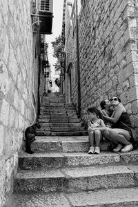 Women sitting on staircase of building