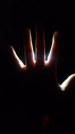 Close-up of human hand against black background