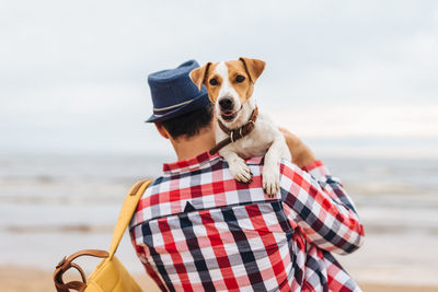 Dog standing on beach against sky