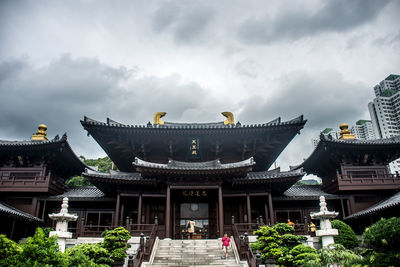 Panoramic view of buildings against cloudy sky