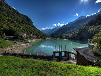 Scenic view of lake and mountains against blue sky