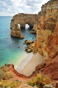 Rock formations by sea against sky