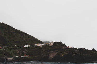 Scenic view of sea and mountains against clear sky