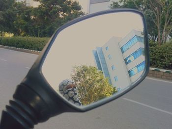 Reflection of man on side-view mirror of car