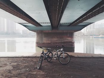 Bicycles under bridge over river