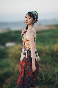 Portrait of young woman standing at beach