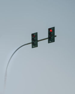 Low angle view of road signal against clear sky