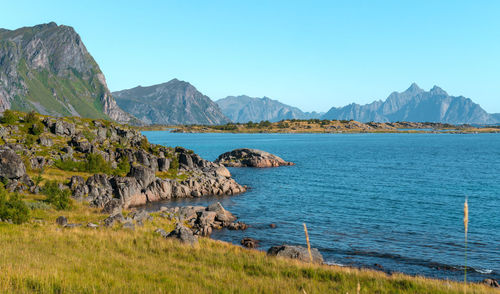 Scenic view of sea and mountains against clear sky