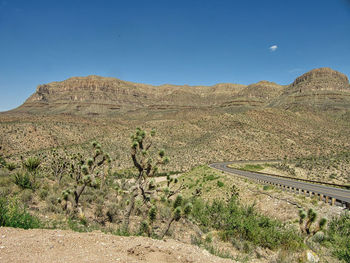 Scenic view of desert against clear blue sky