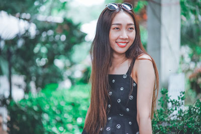 Portrait of a smiling young woman standing outdoors