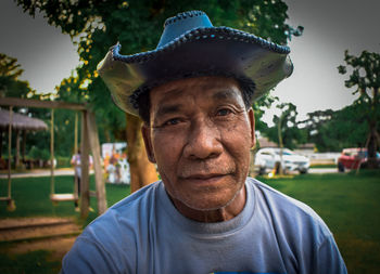 Portrait of senior man wearing hat sitting at park