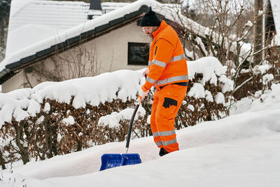 Full length of man shoveling snow during winter