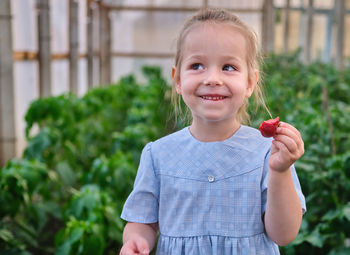 Portrait of cute girl holding fruit