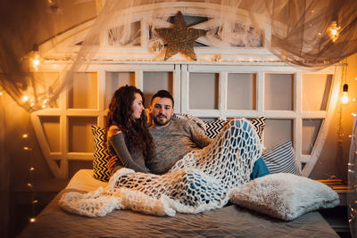 Young couple sitting in corridor