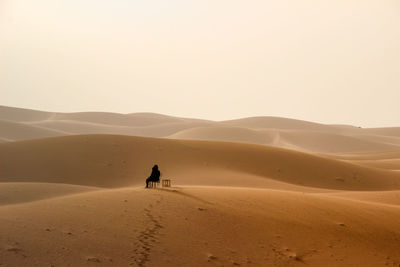 Full length of woman on sand dune in desert against sky