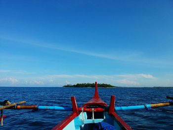 Cropped image of boat in sea against blue sky