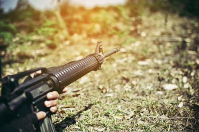 Cropped image of military office aiming weapon on field