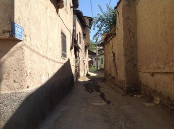 Footpath amidst buildings against sky