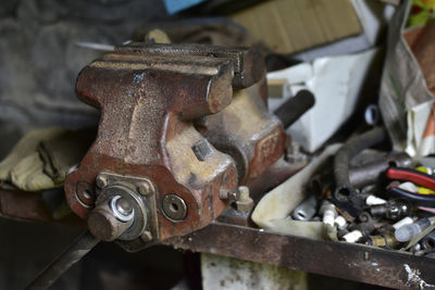 Red massive locksmith iron vise on an iron table