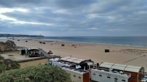 Scenic view of beach against cloudy sky