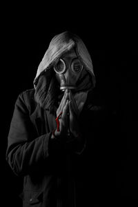Close-up of a man wearing gas mask over black background