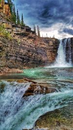 Scenic view of waterfall against sky