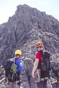 Rear view of man on rock in mountains against sky