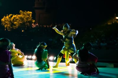 Statues in illuminated park at night