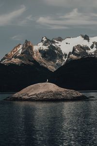 Scenic view of snowcapped mountains by sea against sky