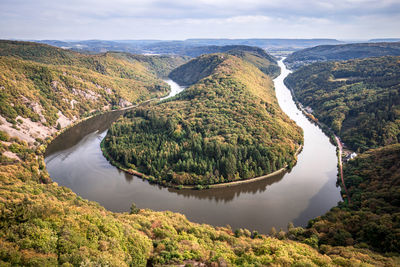 High angle view of river amidst mountains against sky