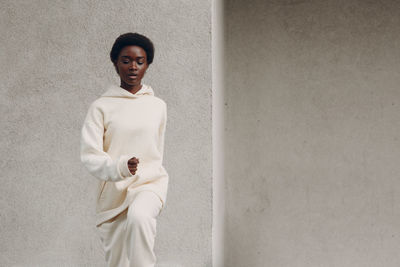 Portrait of woman standing against wall