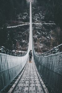 Rear view of man on railroad tracks during winter