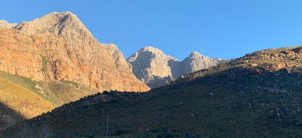 Scenic view of mountains against clear blue sky