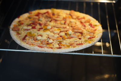 Close-up of heating frozen fast-food pizza in oven