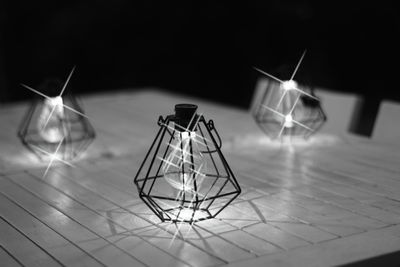 Close-up of electric lamp on table in monochrome