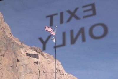 Low angle view of american flag seen through bus window with text