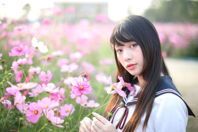 Portrait of beautiful woman with pink flower