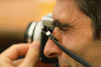 Cropped image of man photographing with camera