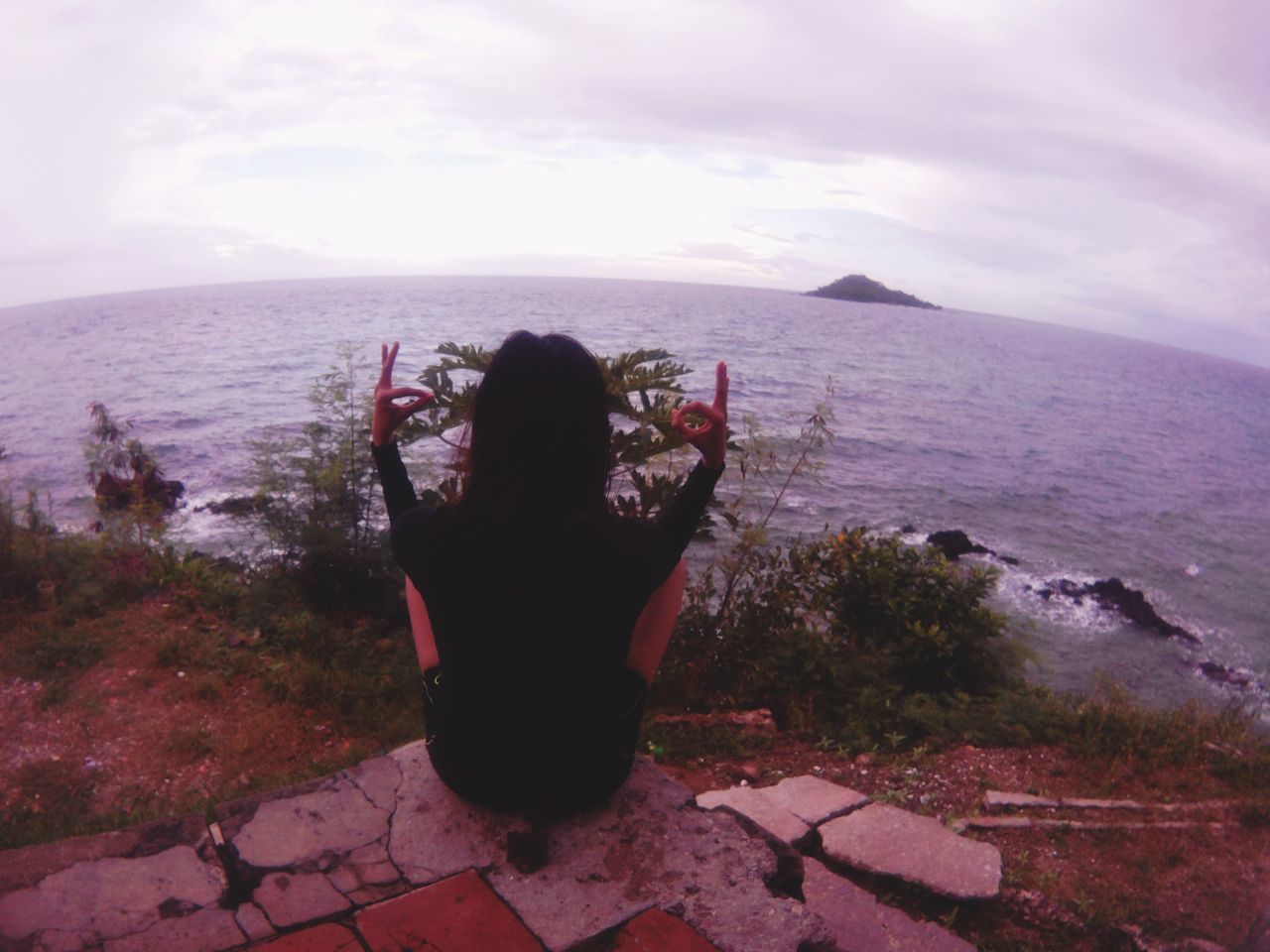 REAR VIEW OF WOMAN LOOKING AT SEA SHORE AGAINST SKY