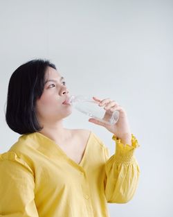 Full length of a beautiful young woman drinking glass