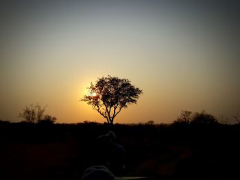 Low section of silhouette man on field against clear sky