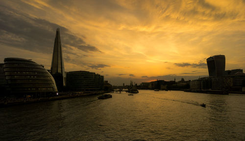 View of buildings at waterfront during sunset