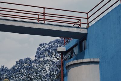 Low angle view of elevated walkway on building against sky