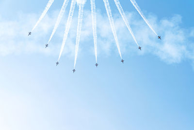 Low angle view of airplanes flying against sky