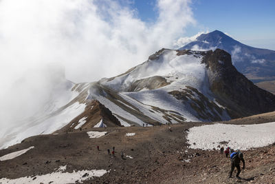 People walking on mountain against sky