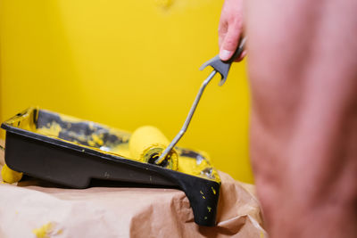 Close-up of person working on yellow machine