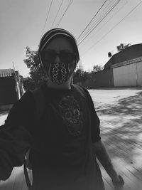 Portrait of man standing against sky in city